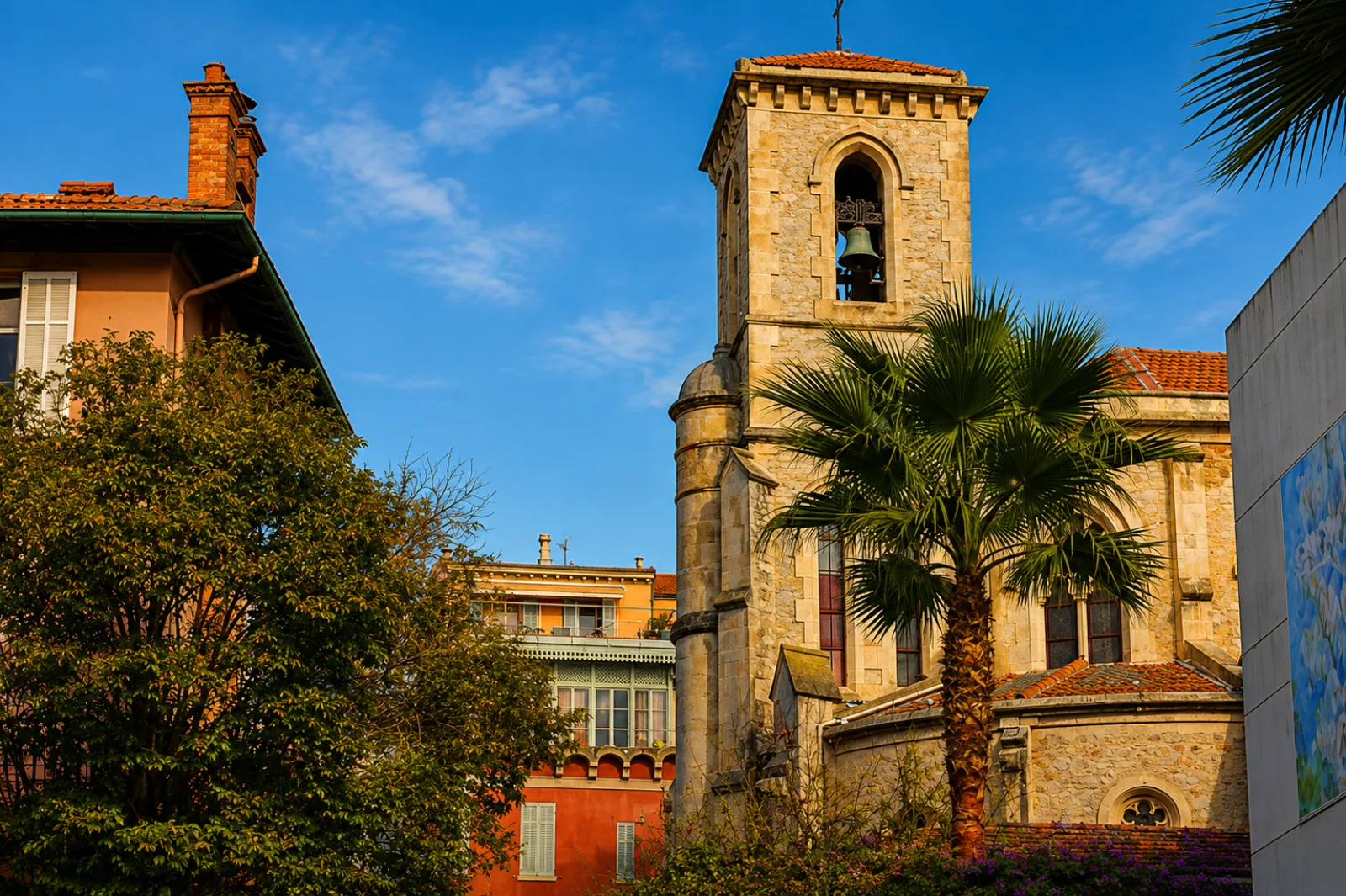 Le clocher de pierre du vieux Cannet entre palmiers et façades ocre — un village étagé sur les collines qui dominent la baie de Cannes