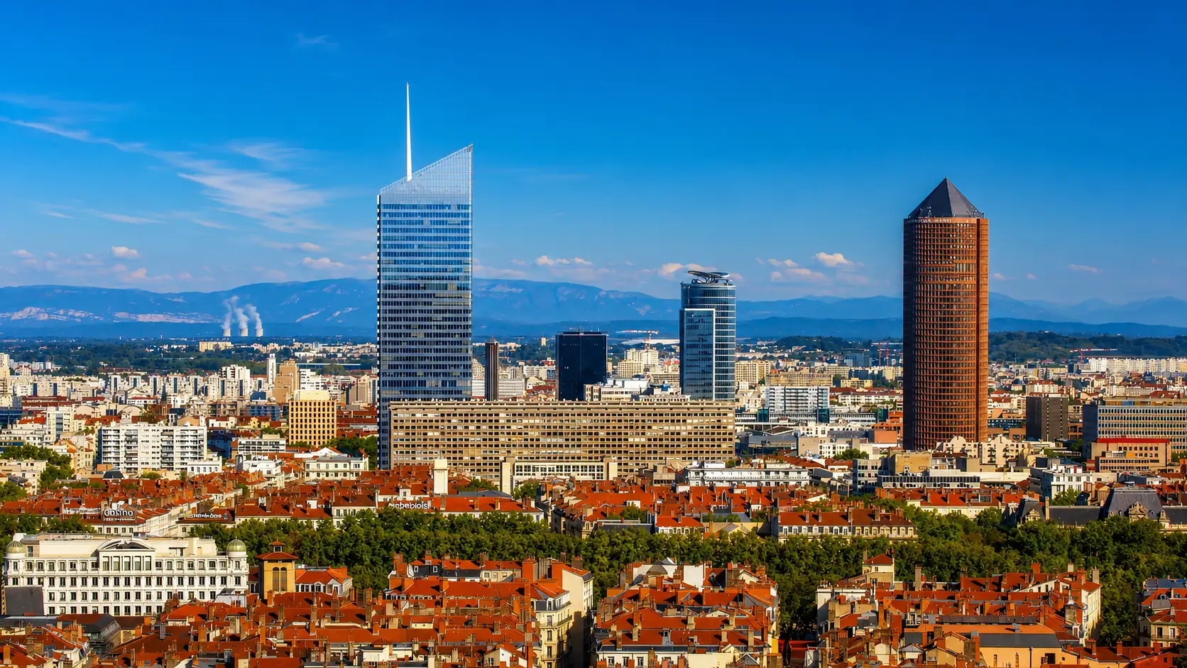 La skyline de la Part-Dieu au-dessus des toits lyonnais : des tours ancrées profond dans les alluvions du Rhône, les reliefs à l'horizon