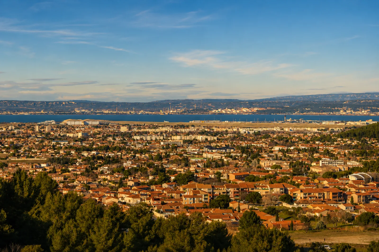 Marignane et l'étang de Berre — la ville pavillonnaire, les pistes de l'aéroport posées sur la rive et les sites industriels de la rive nord