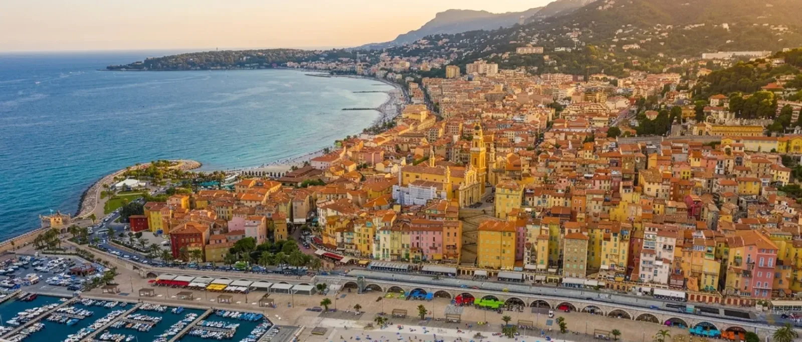 La vieille ville de Menton au-dessus du port — façades ocre étagées sur un versant abrupt, entre mer et montagne