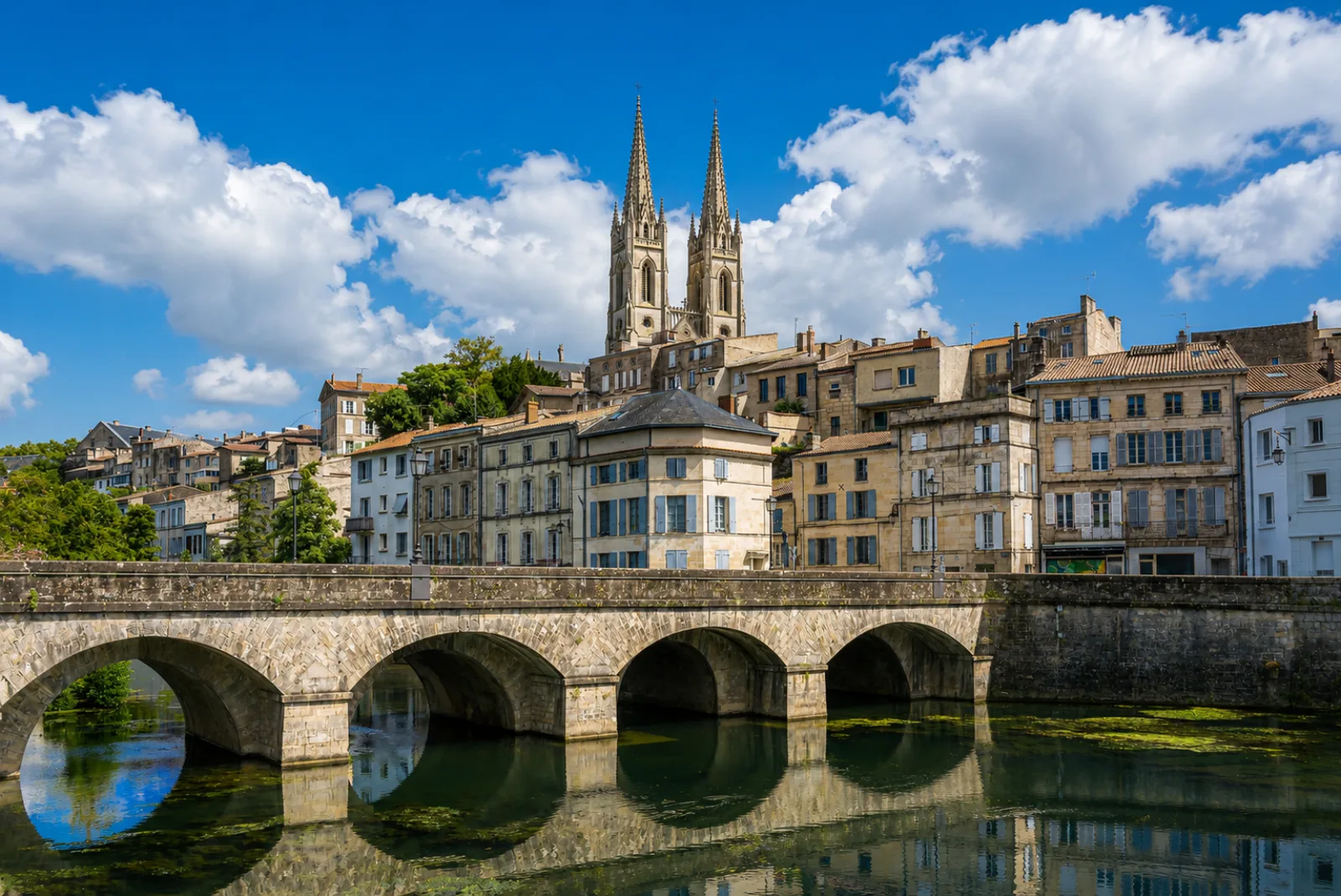 Les flèches de Saint-André dominant les quais de la Sèvre Niortaise et son pont de pierre — Niort au bord de sa rivière, à l'entrée du Marais poitevin