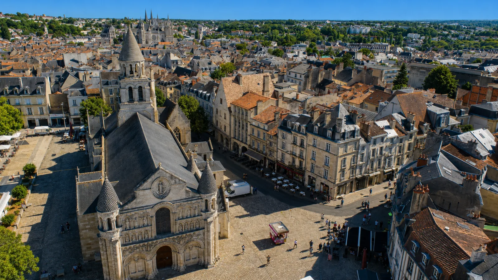La façade romane sculptée de Notre-Dame-la-Grande et sa place pavée au cœur de Poitiers — la ville ancienne serrée sur son promontoire calcaire entre Clain et Boivre