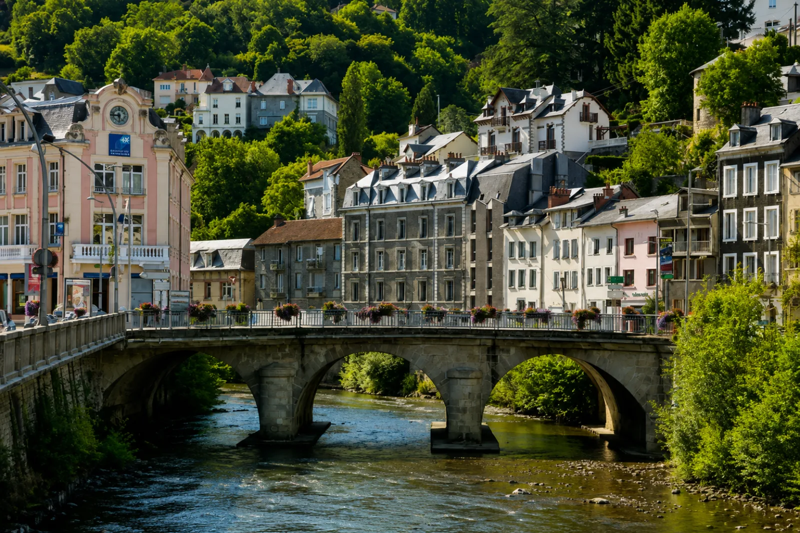 La Corrèze franchie par un pont de pierre à Tulle — maisons d'ardoise accrochées aux versants raides d'une vallée encaissée