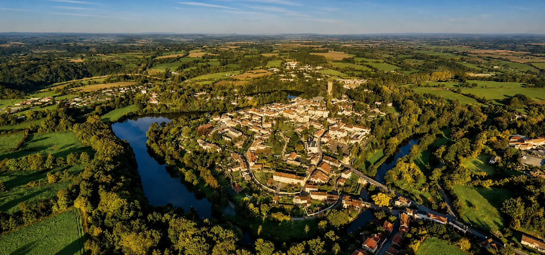Un village vendéen enserré dans le méandre de sa rivière, donjon en sentinelle — le haut-bocage, ses granites et ses vallées encaissées